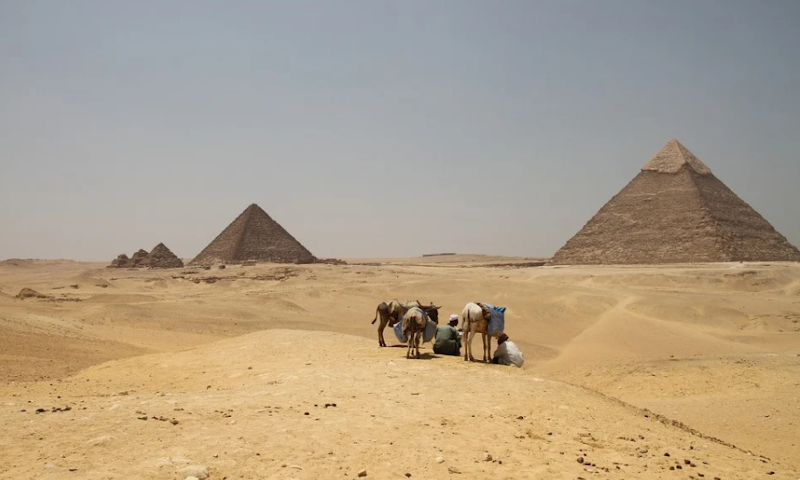 Woestijn en pyramides in Egypte met nomaden op de voorgrond